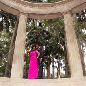 Couple Formal Dressed Standing By Large Stone Columns