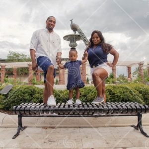 Family Of Three Standing On Bench